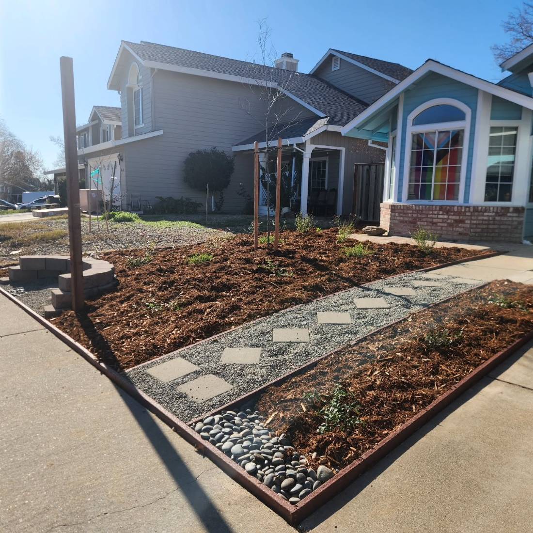 Drought-tolerant front yard with mulch and pavers